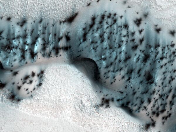 تپه‌های یخ‌زده هلالی شکل در قطب شمال مریخ با تکه‌های ماسه‌ای پوشیده شده‌اند که در آن گرمای هوای بهار، یخبندان را تبخیر کرده است. - اسپوتنیک افغانستان  