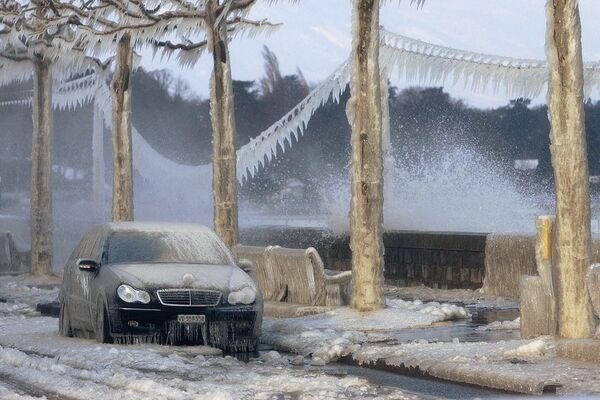 یک ماشین، خطوط تلفن و سواحل دریاچه ژنو در نزدیکی Versoix، سوئیس، پوشیده از یخ است.وزش باد شدید که آب دریاچه را منتقل می کند و دمای زیر نقطه انجماد، منطقه دریاچه ژنو را یخ زده است. - اسپوتنیک افغانستان  