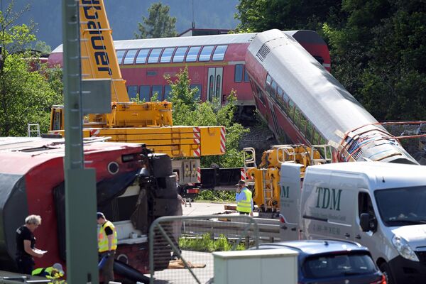 در 4 جون 2022، یک روز پس از حادثه، یک واگن راه‌آهن خارج شده در محل خروج قطار در نزدیکی بورگرین، شمال گارمیش-پارتنکیرشن، جنوب آلمان، دیده می‌شود. - پولیس اعلام کرد که تعداد قربانیان خروج قطار آلمانی از ریل در نزدیکی استراحتگاه آلپ باواریا در 4 جون به 5 نفر افزایش یافت زیرا جسد دیگری از لاشه هواپیما بیرون آمد. بازرسان در حال بررسی کالسکه‌های واژگون شده برای قربانیان و سرنخ‌هایی در مورد علت حادثه در روز 3 جون در نزدیکی گارمیش-پارتنکیرشن، منطقه‌ای که آماده میزبانی نشست G7 در اواخرجون است، بودند. (عکس از کریستین جونسون خبرنگار خبرگزاری فرانسه)   - اسپوتنیک افغانستان  
