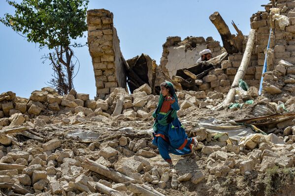 یک کودک در میان خانه های ویران شده  در اسر زلزله در ولسوالی برمل ولایت پکتیکا قدم می زند. 23 جون 2022. - اسپوتنیک افغانستان  