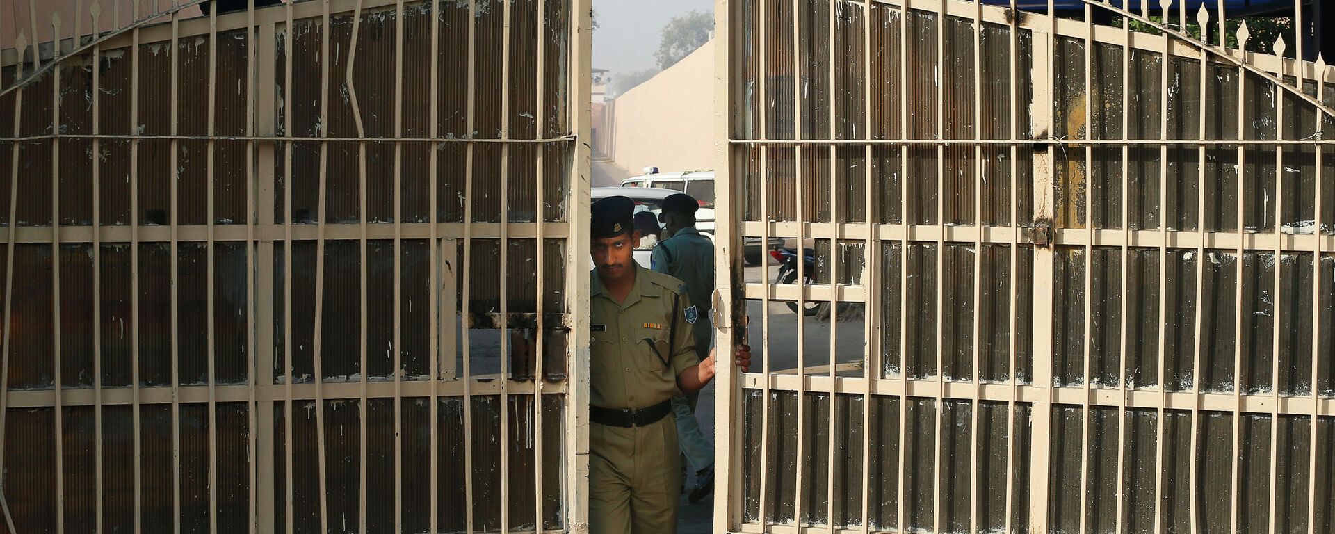 An Indian police officer prepares to close one of the gates at Tihar Jail, the largest complex of prisons in South Asia, in New Delhi, India, Monday, March 11, 2013 - اسپوتنیک افغانستان  , 1920, 01.01.2023