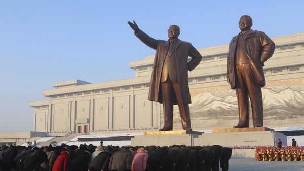 Люди кланяются статуям бывших лидеров Ким Ир Сена и Ким Чен Ира на холме Мансу в Пхеньяне, Северная Корея - اسپوتنیک افغانستان  