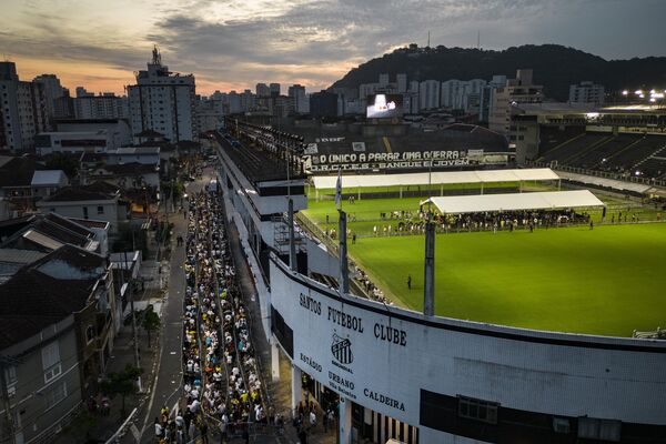 مردم در صف ورود به استادیوم ویلا بلمیرو، جایی که پله، فوتبالیست اسطوره ای برزیلی در ایالت سانتوس برزیل خوابیده است، منتظر هستند.دوشنبه، 2 جنوری 2023 - اسپوتنیک افغانستان  