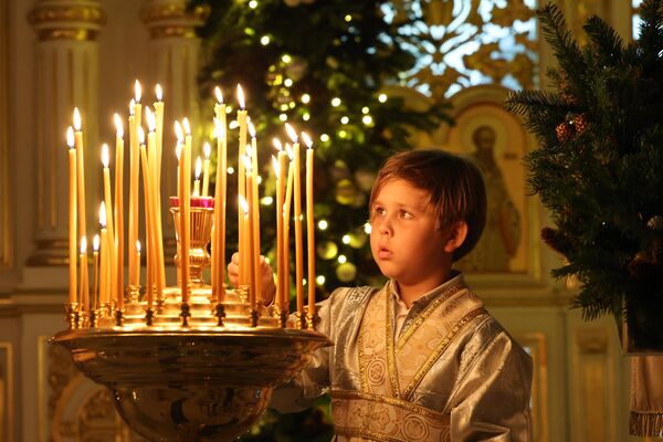 پسرک در عید کریسمس در کلیسای ارتدکس روسیه در شارجه شمع روشن می کند - اسپوتنیک افغانستان  
