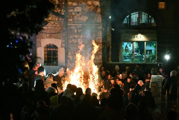 مردم درمراسم سالانه سوزاندن شاخه‌های خشک درخت بلوط به مناسبت شب کریسمس ارتدکس ها در کلیسایی در شهر سارایوو - اسپوتنیک افغانستان  
