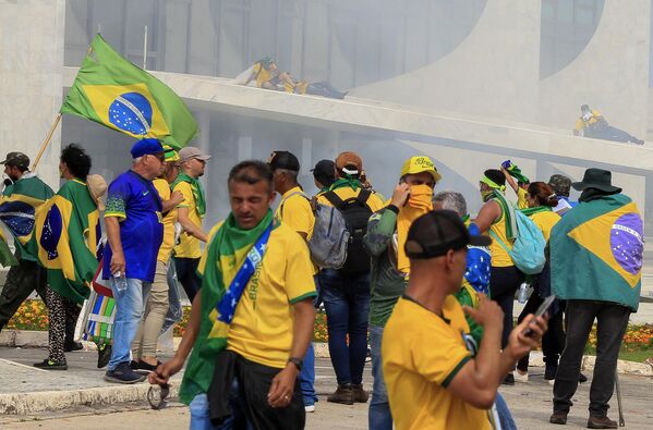 هواداران ژایر بولسونارو، رئیس جمهور سابق برزیل که به کاخ ریاست جمهوری پلانالتو حمله کردند، تحت تأثیر گاز اشک آور پرتاب شده توسط نیروهای امنیتی در برازیلیا قرار گرفتند. - اسپوتنیک افغانستان  