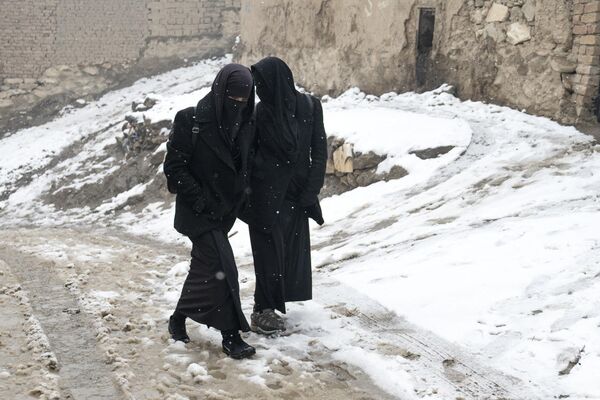 دختران کابل در یک روز برفی در پیس کوچه های کابل در حال راه رفتن هستند.8 جنوری 2023 - اسپوتنیک افغانستان  