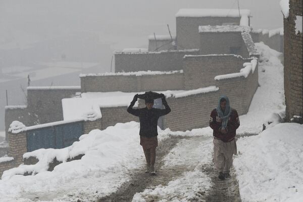 مردی در کابل در حال راه رفتن در پس کوچه های کابل در روز برفی 11 جنوری. - اسپوتنیک افغانستان  
