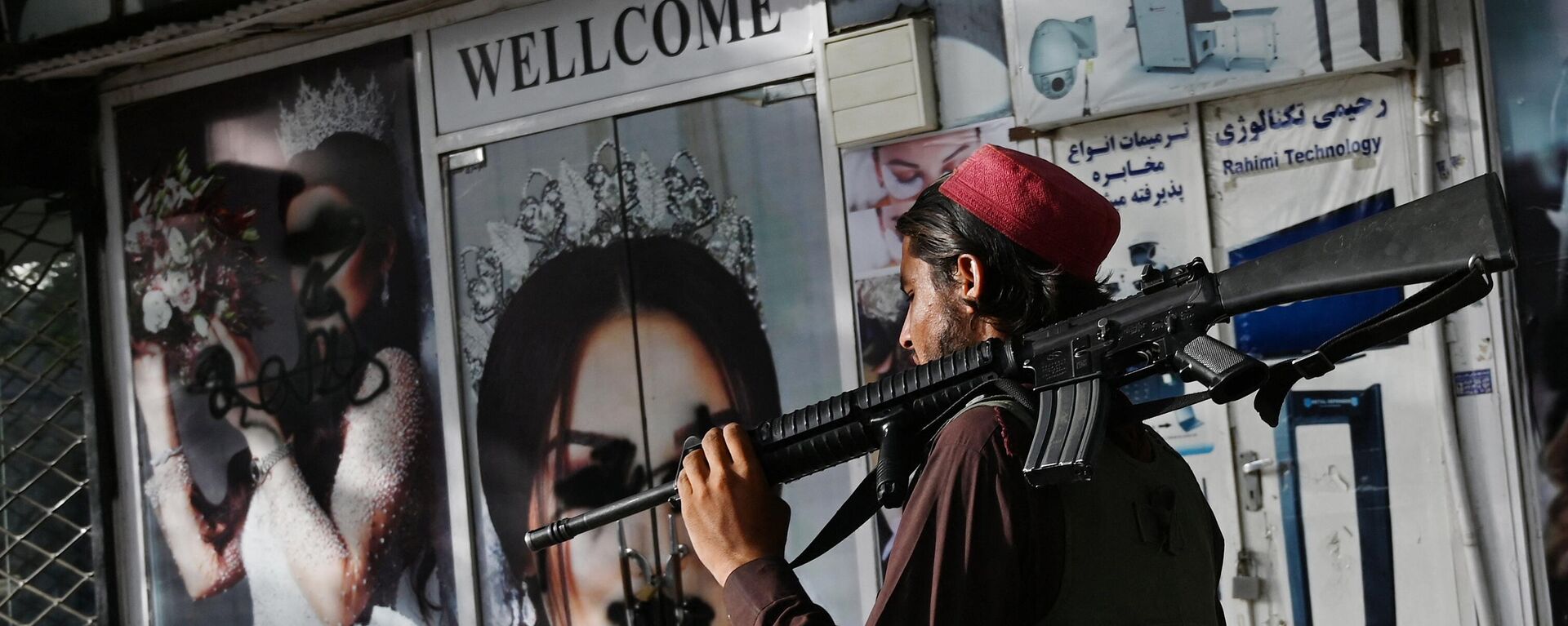Боец движения Талибан проходит мимо кабульского салона красоты с изображениями женщин, лица которых закрашены аэрозольной краской, 2021 год - اسپوتنیک افغانستان  , 1920, 21.01.2023