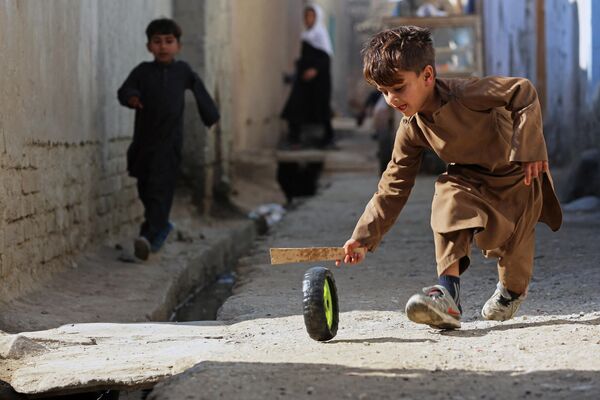 لولک دوانی کودک افغان در کنار کوچه در جلال آباد. - اسپوتنیک افغانستان  