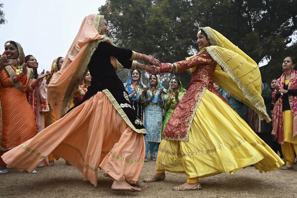 دانشجویان گیدا در طول جشن های جشنواره لوهری در کالج شاهزادا ناند در امریتسار در 13 جنوری 2023 یک رقص محلی پنجابی را اجرا می کنند.(عکس از ناریندر نانو / خبرگزاری فرانسه) - اسپوتنیک افغانستان  