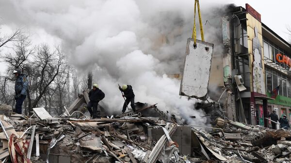 Спасатели на месте разрушенного в результате обстрела со стороны ВСУ торгового центра в Донецке, Россия - اسپوتنیک افغانستان  