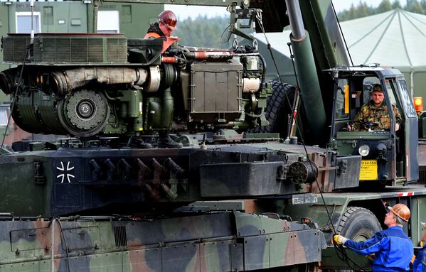 سربازان یک تانک جنگی لئوپارد 2 از نیروهای مسلح آلمان Bundeswehr را در یک اردوگاه در جریان تمرین آموزشی اطلاعاتی &quot;Land Operation Exercise 2017&quot; در منطقه آموزش نظامی در مونستر، شمال آلمان تعمیر می کنند. - اسپوتنیک افغانستان  