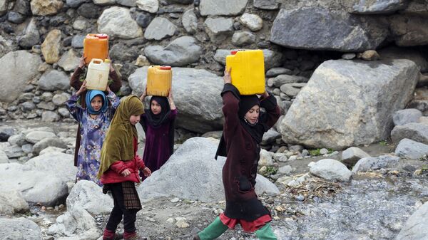Дети несут канистры с питьевой водой после наполнения из ручья в районе Дара-и-Нур провинции Нангархар, Афганистан - اسپوتنیک افغانستان  