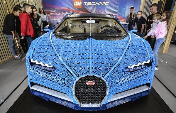 بازدیدکنندگان در نمایشگاهی در پارک گورکی مسکو در 23 جولای 2019، یک خودروی سایز کامل بوگاتی شیرون را که از بلوک‌های LEGO Technic ساخته شده است، بازدید می‌کنند.این مدل که از بیش از 1 میلیون قطعه و وزن 1500 کیلوگرم با حداکثر سرعت 20 کیلومتر در ساعت ساخته شده است، تا 4 آگوست در معرض نمایش است. متخصصان لگو 13.438 ساعت را صرف مهندسی و مونتاژ مدل بدون یک قطره چسب کردند. - اسپوتنیک افغانستان  