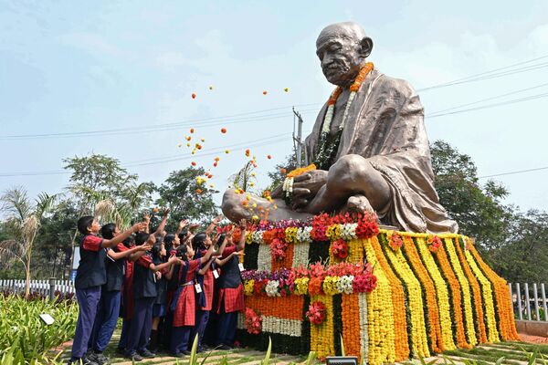 شاگردان  در سالگرد مرگ گاندی در حیدرآباد در 30 جنوری 2023 روی مجسمه مهاتما گاندی گل می پاشند.سالگرد درگذشت گاندی که در هند به عنوان باپو (پدر) شناخته می شود، در این کشور نیز به عنوان روز شهید برگزار می شود.(عکس از NOAH SEELAM / AFP) - اسپوتنیک افغانستان  