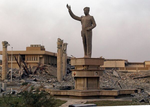 هنگام غروب خورشید در بغداد در 9 اپریل 2003، مجسمه صدام حسین، رئیس جمهور عراق، در میان خرابه های مقر نیروی هوایی عراق ایستاده است. در حالی که رژیم رهبر عراق پس از سه هفته سقوط کرد، تانک ها و نیروهای امریکایی به پایتخت عراق سرازیر شدند. عکس از (رمزی حیدر خبرگزاری فرانسه) - اسپوتنیک افغانستان  
