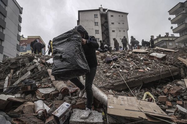 مردم و تیم‌های اورژانس به دنبال افراد زیر آوار در ساختمان ویران‌شده در غازی اینتاپ، ترکیه، دوشنبه، 6 فوریه 2023 هستند. - اسپوتنیک افغانستان  