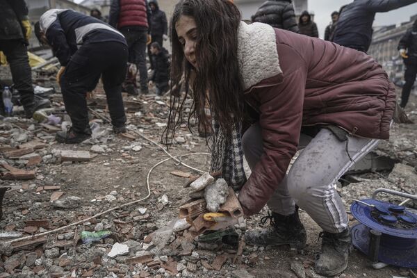 یک زن جوان در حالی که با تیم‌های اضطراری در غازی‌ عینتاب ترکیه به دنبال افراد می‌گردد، - اسپوتنیک افغانستان  