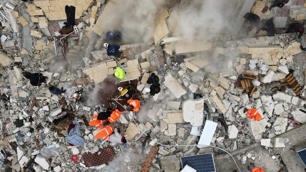 Поиски жертв и выживших под обломками рухнувших зданий после землетрясения в городе Сармада в сирийской провинции Идлиб  - اسپوتنیک افغانستان  