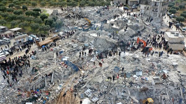 Поиски жертв и выживших среди обломков рухнувших зданий после землетрясения в деревне Бесния недалеко от города Харим, в сирийской провинции Идлиб - اسپوتنیک افغانستان  