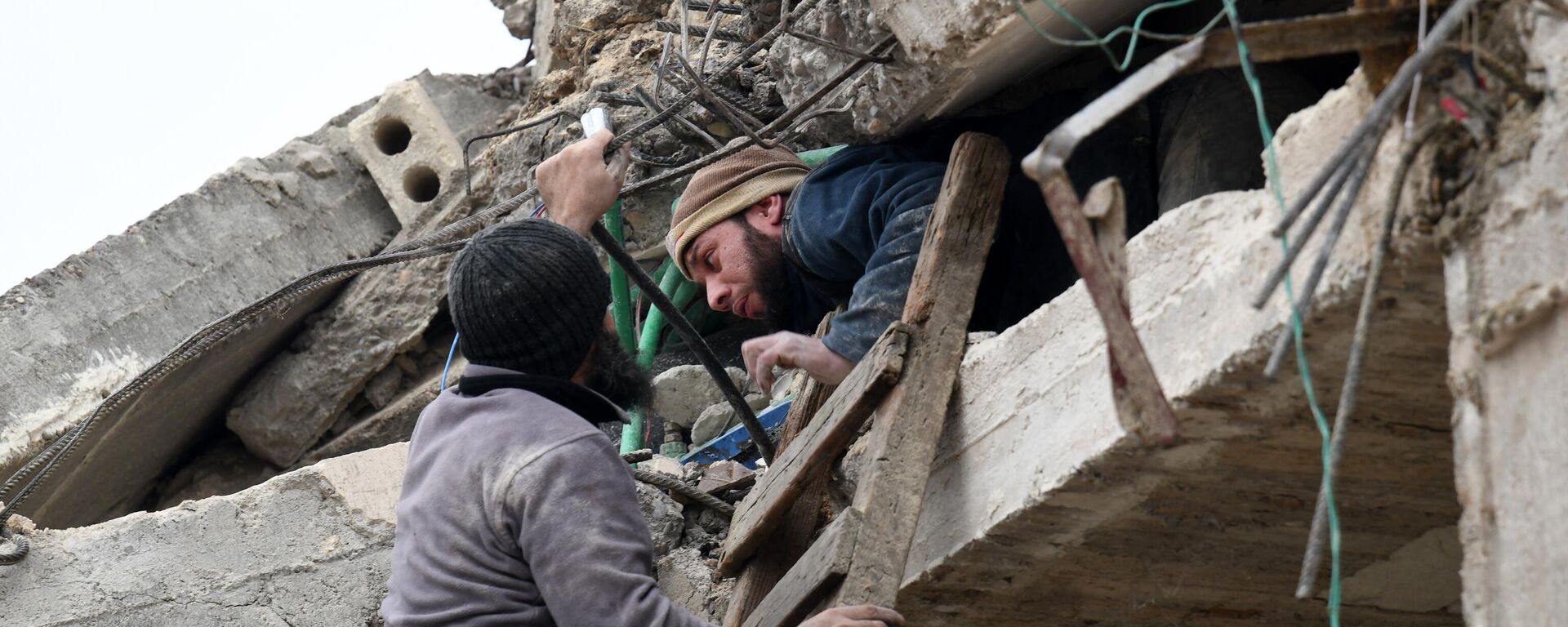 Житель помогает раненому мужчине высвободиться из-под обломков разрушенного здания после землетрясения в городе Джандарис на северо-западе Сирии - اسپوتنیک افغانستان  , 1920, 14.02.2023