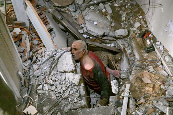 این مرد در 7 فبروری 2023، یک روز پس از زلزله 7.8 ریشتری که جنوب شرق کشور در هاتای لرزاند، در زیر آوار مانده بود و تیم نجات بعد از آوار برداری وی را نجات دادند.امدادگران در ترکیه و سوریه در هنگام حفاری برای بازماندگانی که در اثر زمین لرزه ای که بیش از 5000 کشته بر جای گذاشتند، با هوای سرد، پس لرزه ها و ساختمان های در حال فروریختن مقابله کردند.سازمان جهانی بهداشت روز سه‌شنبه با وعده کمک‌های طولانی‌مدت هشدار داد که ممکن است تا ۲۳ میلیون نفر تحت تأثیر زمین‌لرزه عظیمی قرار بگیرند که هزاران کشته در ترکیه و سوریه گرفته است.(عکس از بولنت کیلیچ / خبرگزاری فرانسه) - اسپوتنیک افغانستان  