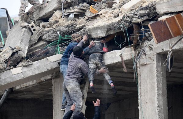 ساکنان یک دختر مجروح را از زیر آوار ساختمان فروریخته پس از زلزله در شهر جندریس در حومه شهر عفرین در شمال غربی سوریه در بخش تحت کنترل شورشیان استان حلب در 6 فبروری 2023 بیرون می آورند.بر اساس گزارش ها، صدها نفر در شمال سوریه پس از زمین لرزه 7.8 ریشتری که از ترکیه آغاز شد و در کشورهای همسایه احساس شد، کشته شدند.(عکس از رامی السید / خبرگزاری فرانسه) - اسپوتنیک افغانستان  