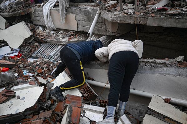 زلزله زدگان یک روز پس از زلزله 7.8 ریشتری جنوب شرق کشور در 7 فوریه 2023 سعی می کنند به دنبال بستگان خود در هاتای بگردند.امدادگران در ترکیه و سوریه در هنگام حفاری برای بازماندگانی که در اثر زمین لرزه ای که بیش از 5000 کشته بر جای گذاشتند، با هوای سرد، پس لرزه ها و ساختمان های در حال فروریختن کار کردند.سازمان جهانی بهداشت روز سه‌شنبه با وعده کمک‌های طولانی‌مدت هشدار داد که ممکن است تا ۲۳ میلیون نفر تحت تأثیر زمین‌لرزه عظیمی قرار بگیرند که هزاران کشته در ترکیه و سوریه گرفته است.(عکس از بولنت کیلیچ / خبرگزاری فرانسه) - اسپوتنیک افغانستان  