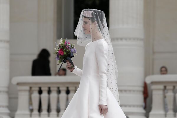 یک مدل لباس عروسی برای مجموعه مد پاییز-زمستان 2022-2021 شنل می پوشد که در Palais Galliera که میزبان موزه مد و تاریخ مد است، که در پاریس ارائه شده است.این عکس سه شنبه، 6جولای 2021، گرفته شده است.(عکس آسوشیتدپرس/لوئیس جولی) - اسپوتنیک افغانستان  