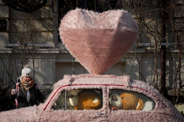 زنی در بخارست، رومانی، سه شنبه، 14 فبروری 2023، در کنار ماشینی که با خز تزئین شده و خرس عروسکی پوشیده شده است، قدم می زند.روز ولنتاین هرگز قبل از سقوط حکومت کمونیستی در رومانی در سال 1989 جشن گرفته نشد، روز ولنتاین در سال های بعد محبوبیت بیشتری پیدا کرد و اکنون به طور گسترده توسط جوانان رومانیایی پذیرفته شده است.(عکس / اندریا الکساندرو) - اسپوتنیک افغانستان  