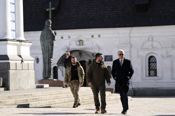 جو بایدن، رئیس جمهور ایالات متحده، سمت راست، با رئیس جمهور اوکراین ولودیمیر زلنسکی در کلیسای جامع گنبد طلایی سنت مایکل در طی یک بازدید از پیش اعلام نشده در کیف، دوشنبه، 20 فبروری 2023 قدم می زند.د - اسپوتنیک افغانستان  