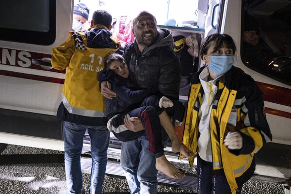 پسربچه ای پس از مجروح شدن در آخرین زلزله در هاتای ترکیه در دوشنبه 20 فبروری 2023 به آمبولانس منتقل می شود. - اسپوتنیک افغانستان  