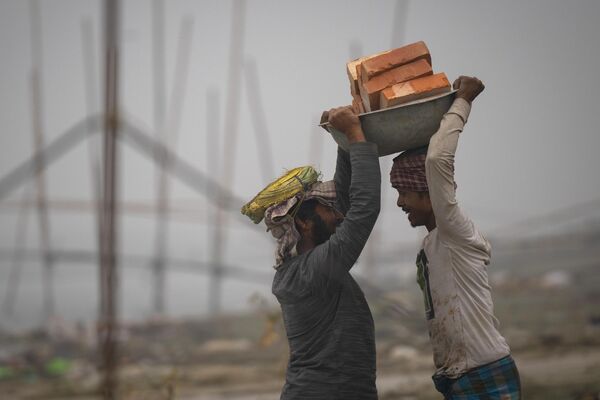 کارگران در حالی اتتقال خشت ها در رودخانه برهماپوترا، گواهاتی هند. - اسپوتنیک افغانستان  