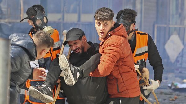 Палестинцы уносят раненого во время израильского рейда в оккупированном городе Наблус  - اسپوتنیک افغانستان  