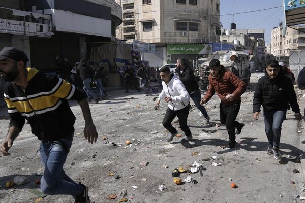 فلسطینیان در جریان درگیری با نیروهای اسرائیلی در شهر نابلس کرانه باختری روز چهارشنبه در حال فرار هستند. - اسپوتنیک افغانستان  