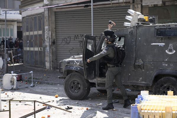 یک افسر شبه نظامی پلیس مرزی اسرائیل در جریان درگیری ها در شهر نابلس کرانه باختری به سوی فلسطینی ها گاز اشک آور پرتاب کرد. - اسپوتنیک افغانستان  