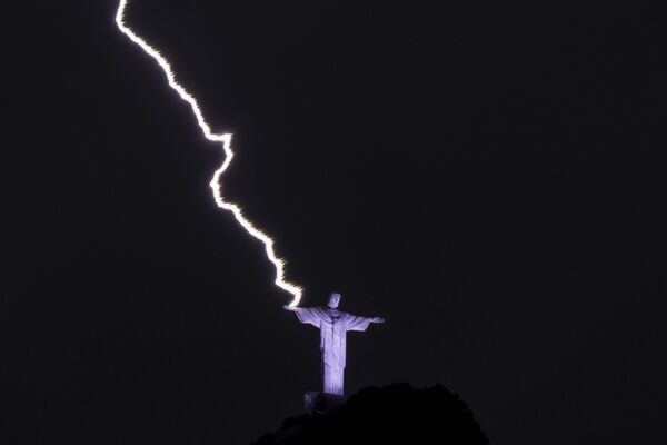رعد و برق به بازوی مجسمه ای مسیح نجات دهنده در کوه کورکووادو در ریودوژانیرو برزیل در 21 فیبروری 2023 برخورد می کند. - اسپوتنیک افغانستان  