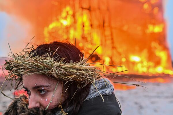 دختری در هنگام سوزاندن سازه هنری دیوار چهارم به شکل مکعب 19 متری در جشن ماسلنیتسا در پارک هنری نیکولا-لنیفتس، منطقه کالوژسکی. - اسپوتنیک افغانستان  