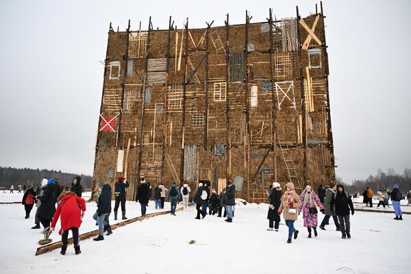 سازه هنری &quot;دیوار چهارم&quot; به شکل یک مکعب 19 متری، مونتاژ شده از مواد بازیافتی، از دفتر &quot;NOYD - فیلم کوتاه&quot; در جشن Maslenitsa در پارک هنری نیکولا-لنیفتس، منطقه کالوگا. - اسپوتنیک افغانستان  
