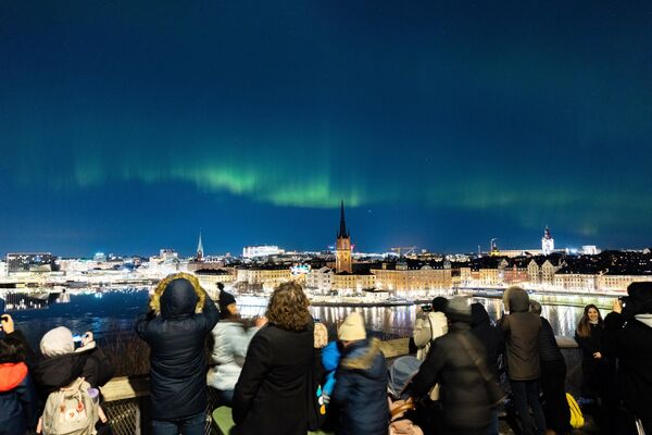 مردم در مرکز استکهلم شفق قطبی را تماشا می کنند. - اسپوتنیک افغانستان  