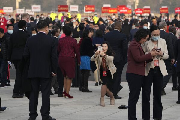 یکی از کارکنان پس از جلسه افتتاحیه کنگره مشورتی سیاسی خلق چین در تالار بزرگ مردم در پکن عکس می گیرد. - اسپوتنیک افغانستان  