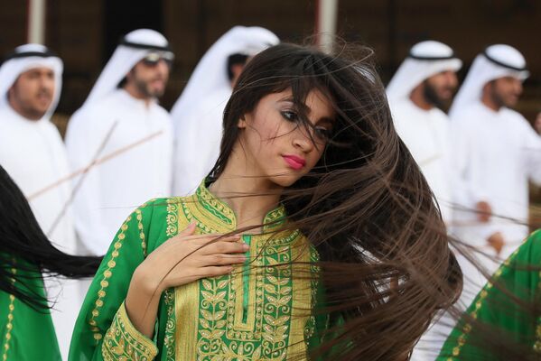  زن اماراتی یک رقص سنتی را در طول جشنواره شتر در میدان اسب دوانی سویهان در العین در حومه ابوظبی اجرا می کند. این جشنواره شامل مسابقه زیبایی شتر، سوق سنتی، حراج شتر و مسابقات صنایع دستی سنتی است - اسپوتنیک افغانستان  