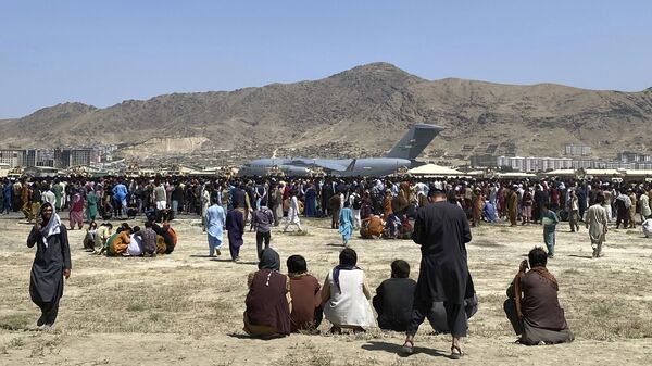 Сотни людей собрались возле транспортного самолета C-17 ВВС США по периметру международного аэропорта в Кабуле, Афганистан. - اسپوتنیک افغانستان  