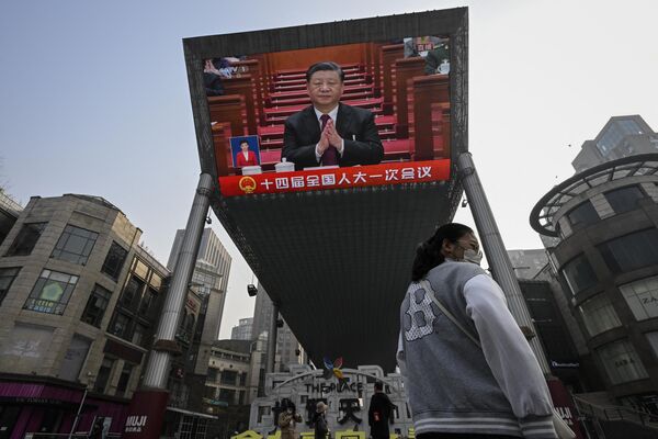 یک صفحه نمایش در فضای باز پوشش خبری زنده از شی جین پینگ رئیس جمهور چین را در طول جلسه افتتاحیه کنگره ملی خلق (NPC) در تالار بزرگ مردم، در امتداد خیابانی در پکن در 5 مارس 2023 نشان می دهد. - اسپوتنیک افغانستان  