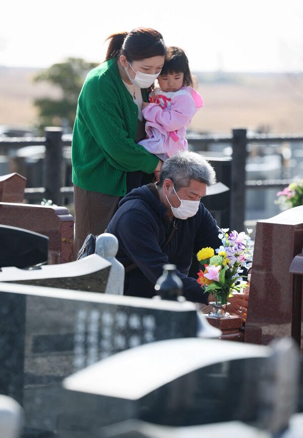 مردم از قبرستان در شهر نامی در ولایت فوکوشیما بازدید می کنند. - اسپوتنیک افغانستان  