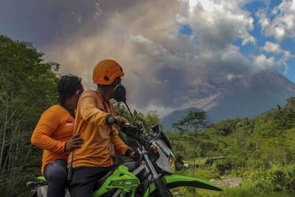 مردان شاهد انتشار مواد آتشفشانی کوه مراپی در جریان فوران در سلمان اندونزیا، شنبه، 11 مارچ 2023 هستند. (نگاره از خبرنگار خبرگزاری فرانسه سلامت ریادی)  - اسپوتنیک افغانستان  