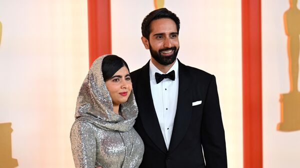 Пакистанская правозащитница Малала Юсуфзай с мужем до начала 95-й церемонии вручения наград премии Оскар в Лос-Анджелесе   - اسپوتنیک افغانستان  