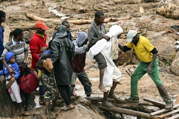 یک مرد در بلانتایر، مالاوی در حال کمک کردن به دیگران.طوفان بی امان فردی که هم اکنون جنوب آفریقا را درنوردیده است، از زمانی که شنبه شب برای دومین بار این قاره را درنوردید، بیش از 50 نفر را در مالاوی و موزامبیک کشته است. - اسپوتنیک افغانستان  