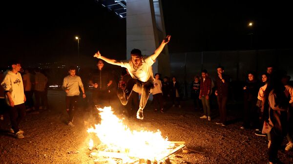 Иранец прыгает через костер во время Праздника огня в преддверии Иранского нового года, 14 марта 2023 - اسپوتنیک افغانستان  
